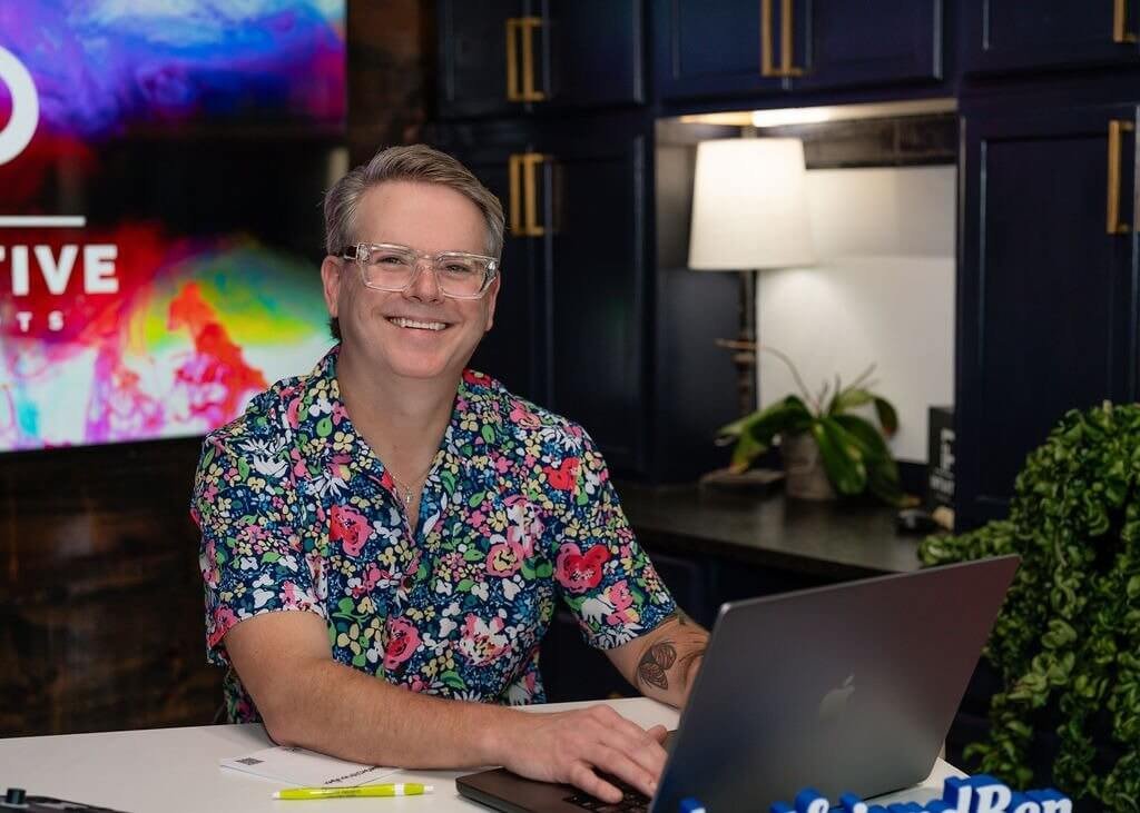 Life coach Ben working at a desk with a laptop during a professional personal life coaching session.