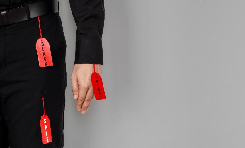 Person dressed in black with red sale price tags hanging from their clothing, symbolizing how labels reduce human identity to a single word or category and limit personal growth