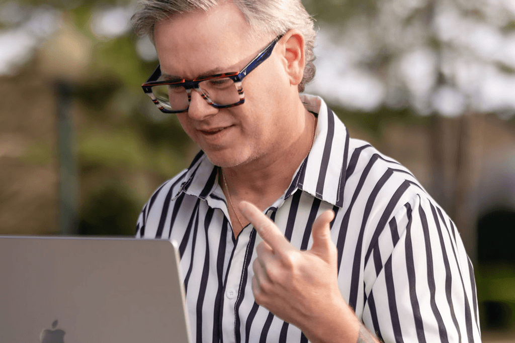 Life coach Ben speaking while working on a laptop during an online personal life coaching session.